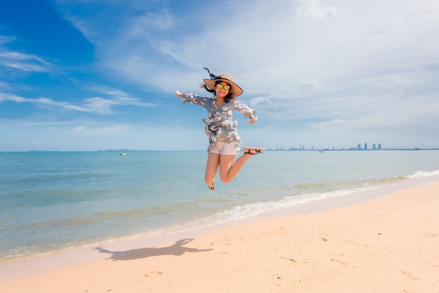 여자는 행복하고 그녀의 휴가에 점프.