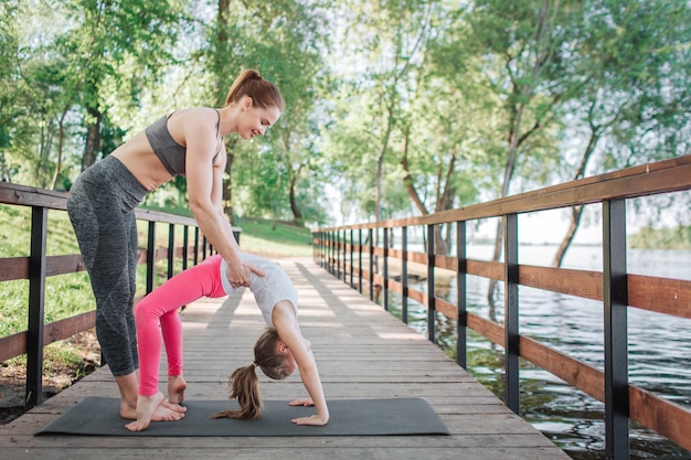 Woman is helping her student to do a bridge pose