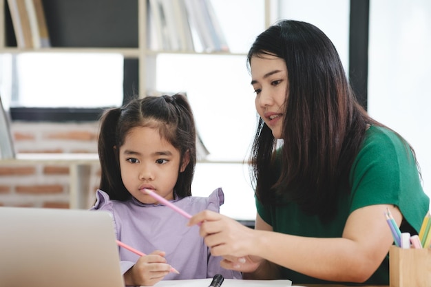 Photo a woman is helping a young girl with her homework