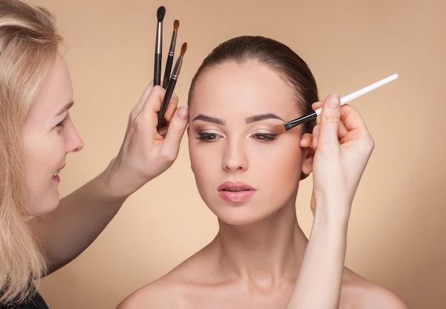 The woman is holding a brush and smiling