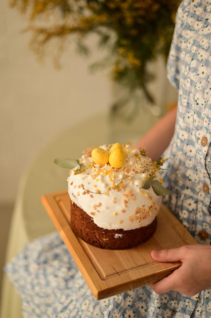 A woman is holding a cake with a tray of eggs on it.