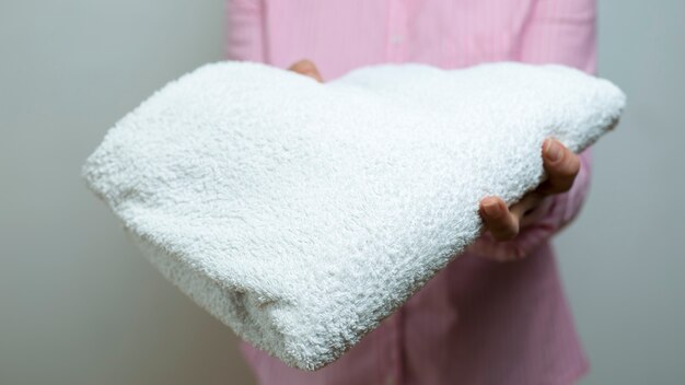 A woman is holding a clean towel. 