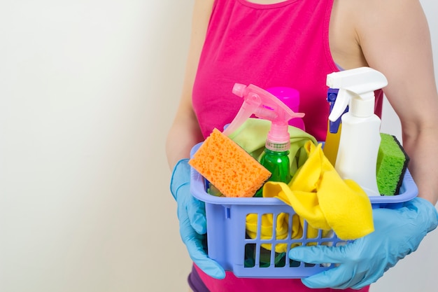 A woman is holding cleansers for washing. Copy space.