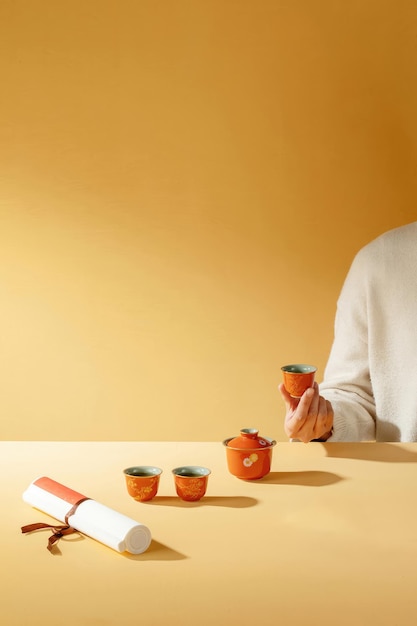 A woman is holding a cup of tea and a white paper on the table Quietly drinking tea