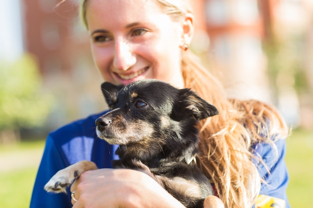 La donna sta tenendo un cane all'aperto