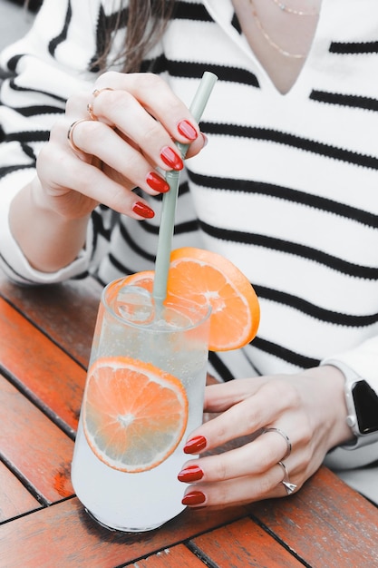 a woman is holding a glass with a straw in her hand and a straw in the other hand