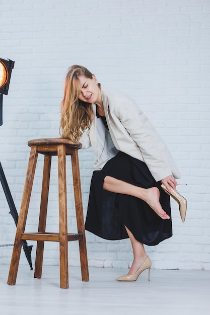 A woman is holding her leg she is wearing high heeled shoes and
her legs hurt the woman is wearing a black dress and beige high
heel shoes leg pain from high heels