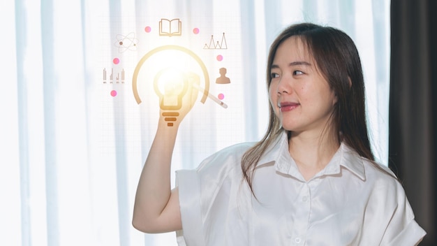 A woman is holding a lightbulb with a line of icons on the screen.