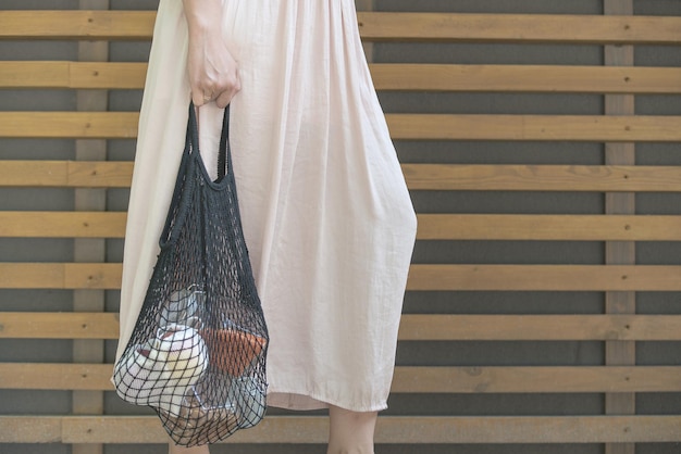 Woman is holding mesh bag with products