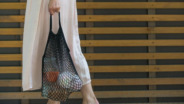 Woman is holding mesh bag with products