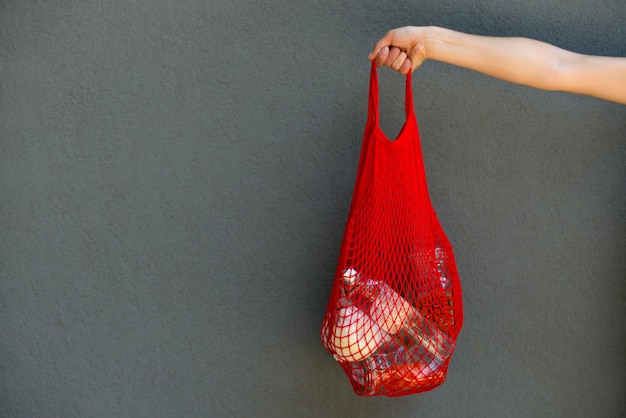 Woman is holding mesh bag with products