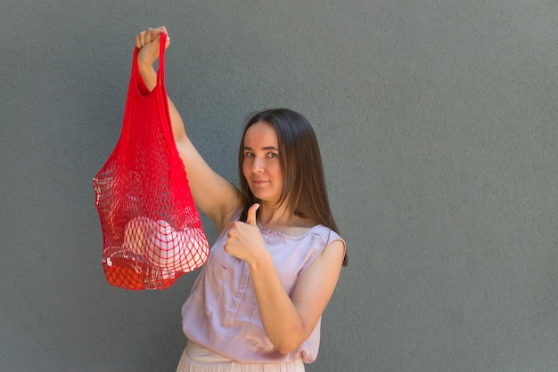 Woman is holding mesh bag with products