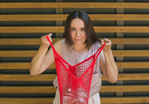 Foto la donna tiene in mano una borsa a rete con prodotti