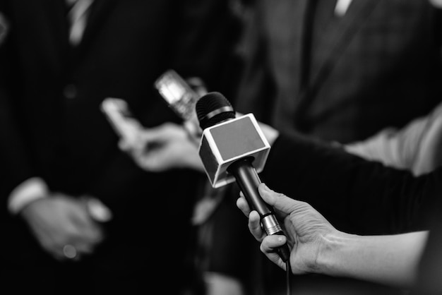 A woman is holding a microphone in front of a group of people