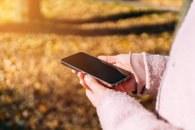 Woman is holding a modern smartphone in her hands.