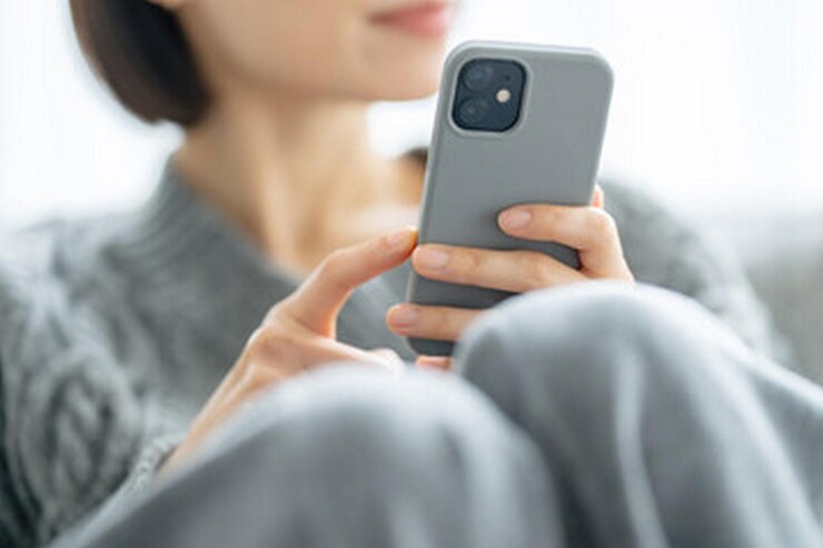 Photo 女性が顔にカメラを持った電話を握っている