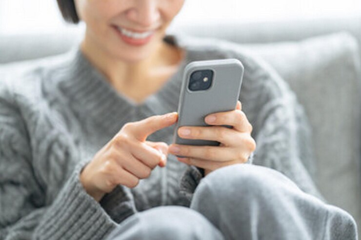 Photo 女性が顔に笑顔で電話を握っている