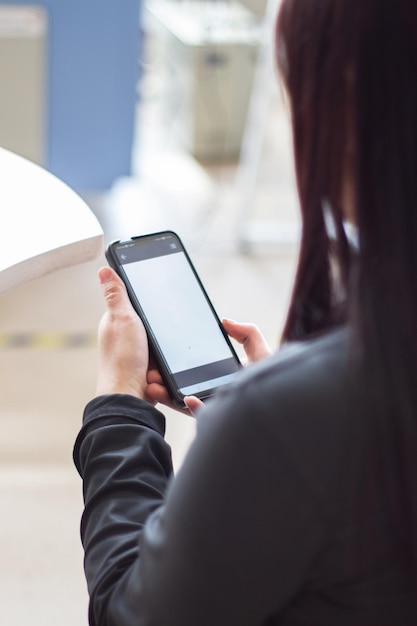 A woman is holding a phone with a white screen that says'the word'on it '