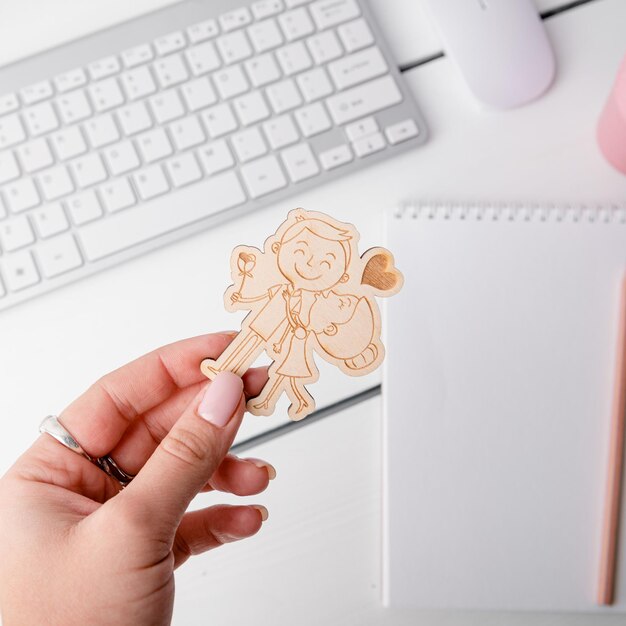 Foto una donna tiene in mano un adesivo di una ragazza con una tazza rosa sulla scrivania.