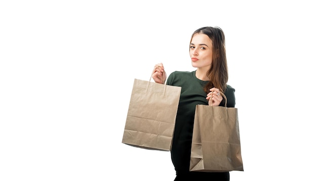 Woman is holding two grocery shopping bags on white background. Isolated background.