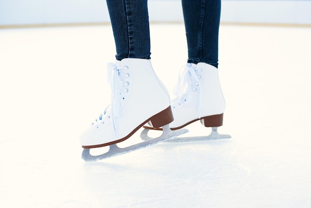 Woman is ice skating on rink close up