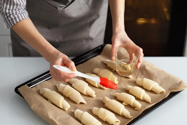 Foto una donna è in cucina a cucinare bagel con marmellata dolce pasticceria con le proprie mani