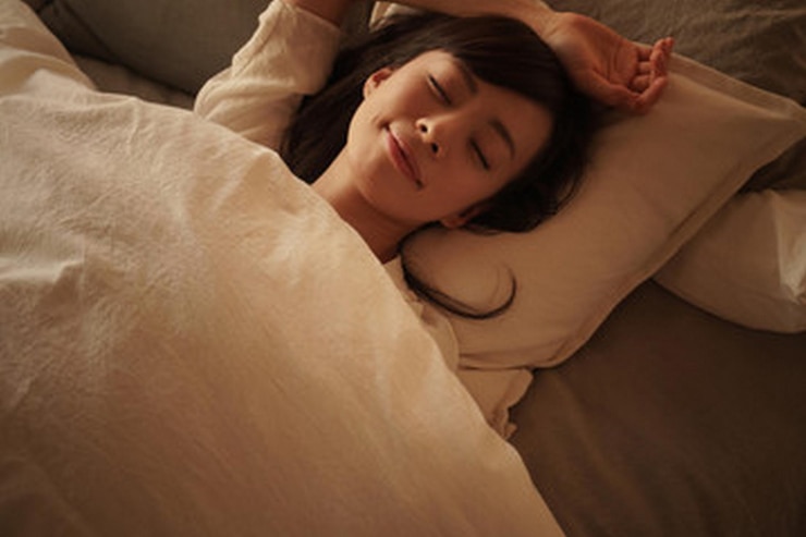Photo a woman is laying in bed with her eyes closed