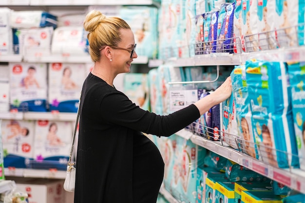 A woman is looking for baby accessories or diaper in the shelf