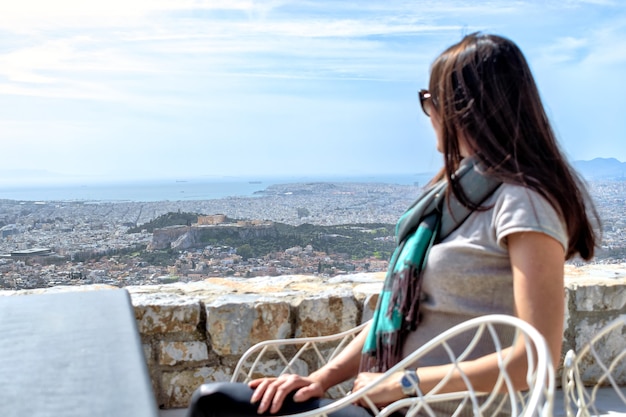 Woman is looking on a big city Athens and the Acropolis hill