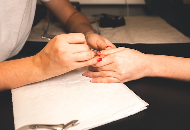 Woman is making a manicure. Salon procedures at home. Beautiful hands and nails.