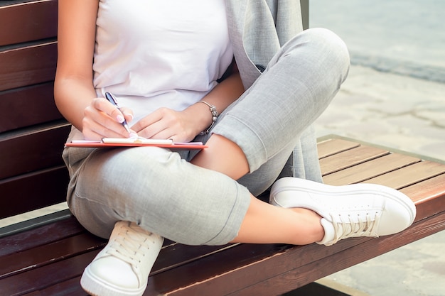 Woman is making notes in notebook