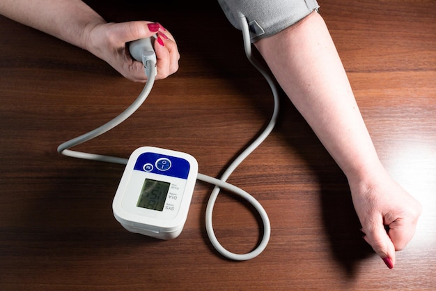 Woman is measuring blood pressure at home Electronic sphygmomanometer Medical treatment photo