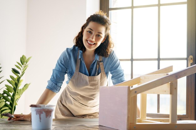 Photo woman is painting a wooden stepladder