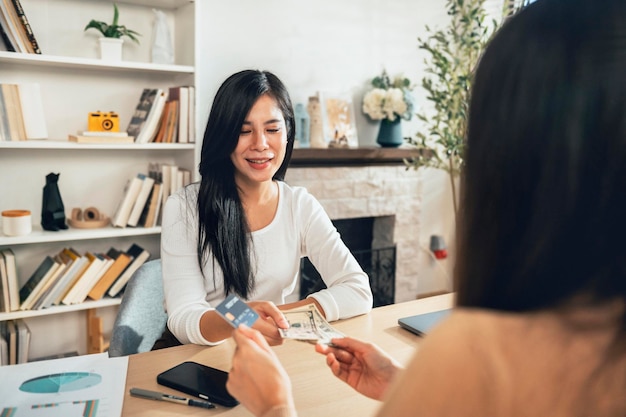 Foto la donna sta pagando in contanti e con carta di credito per effettuare un acquisto concetto finanziario