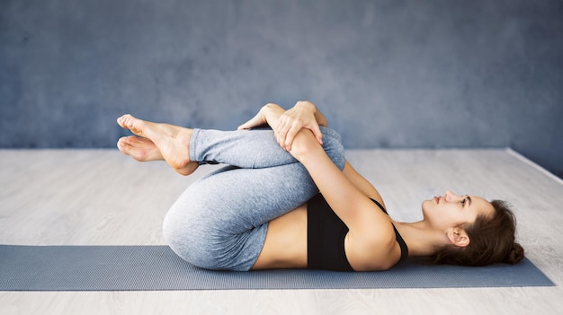a woman is performing a yoga pose on a mat demonstrating flexibility and balance she appears focused