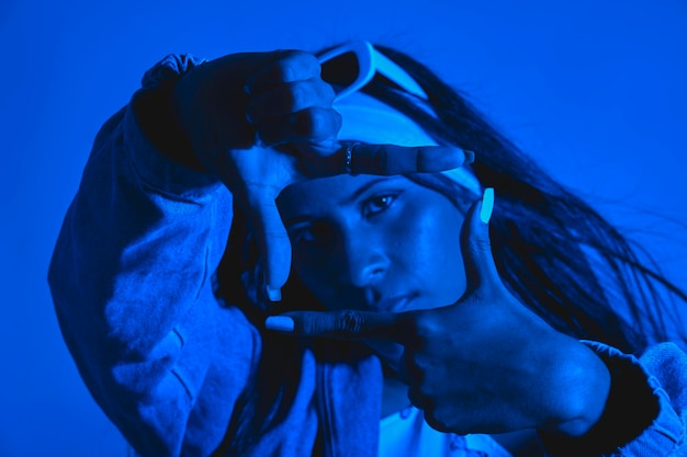 A woman is posing for a picture with her hands together in a frame Urban dancer concept