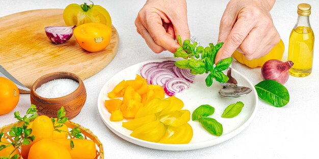 A woman is preparing a tomato salad ripe vegetables herbs aromatic spices olive oil home cooking fresh ingredients banner format