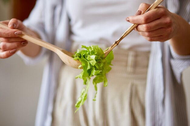 女性は台所で野菜サラダを準備しています