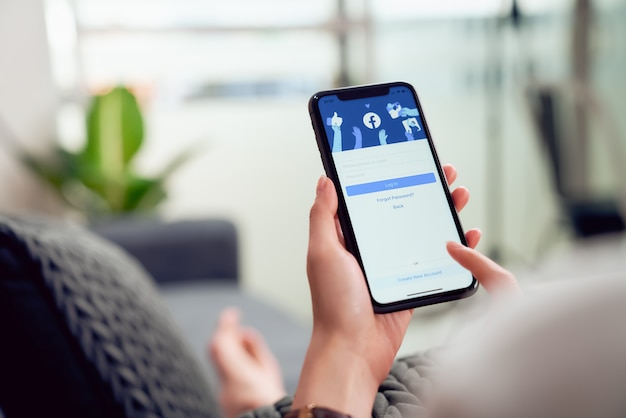 Woman is pressing the Facebook screen on smartphone