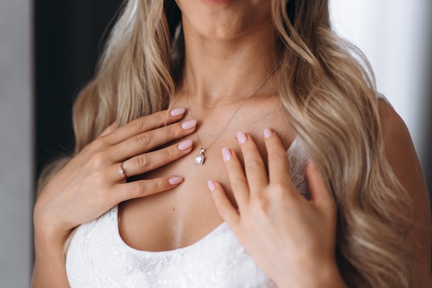 Photo a woman is putting a necklace on her chest.