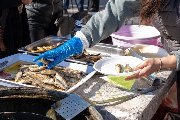 여자가 그릴에 생선 접시를 놓고 있다