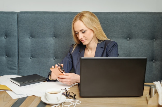 女性は彼女の携帯電話でメッセージを読んでいます。