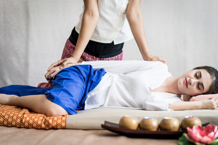タイのマッサージスパで腕のマッサージを受けている女性