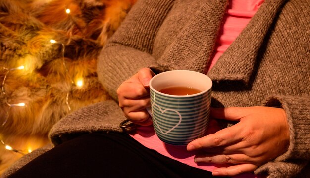 Woman is recovering with a cup of tea on cold autumn days