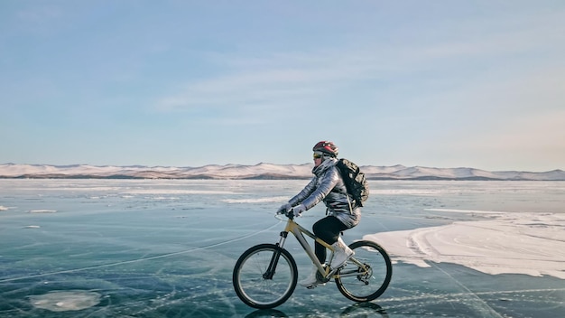 Woman is riding bicycle on the ice Tires on bike are covered wi