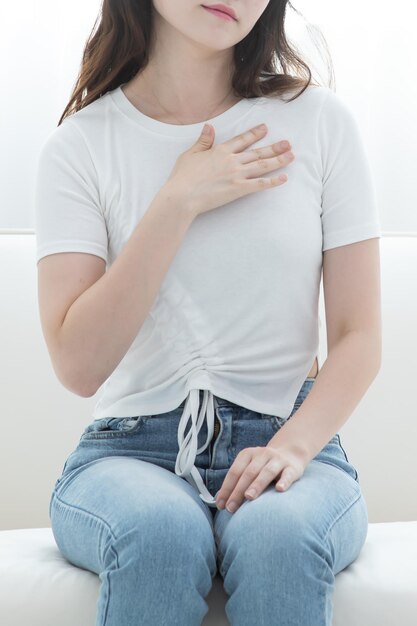 A woman is rubbing her shoulders and neck