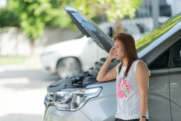 woman is sad because of a broken car