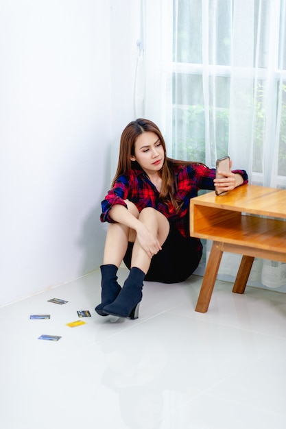 The woman is serious and is sitting in the corner of the room. Clear concept