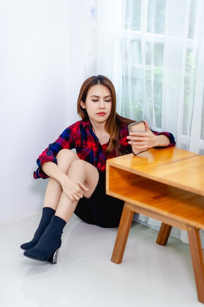 Woman is serious and sitting in the corner of the room