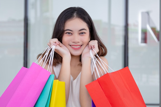 Photo woman is shopping and holding paper bags